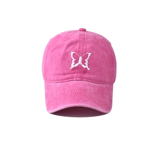 Detailed embroidery of a white butterfly on a vintage pink washed cotton baseball cap