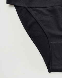 Detailed close-up of the elastic waistband and fine stitching on black cotton panties