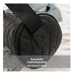 Detail view of the black quilted nylon barrel bag showing texture and stitching