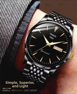 Detail of a business watch with a black dial and golden hands on a man's suit sleeve