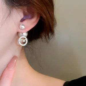 Elegant double pearl earrings with a circular rhinestone pendant and letter charm