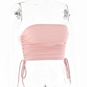 Détail d'un haut bustier en maille rose avec cordon de serrage réglable et design froncé