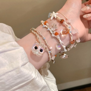 Detail of handmade woven bracelet set with starfish charms and colorful beads for summer