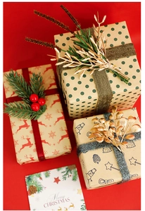 Close-up of DIY Christmas gift wrapping boxes with reindeer patterns and festive ribbons
