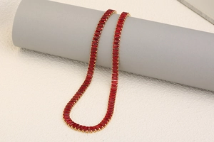 Detail of 18K gold plated tennis necklace featuring rectangular red zircon gemstones