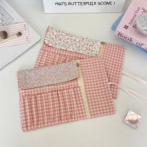 Detailed interior of floral fabric makeup brush roll showing slots and zipper pouch