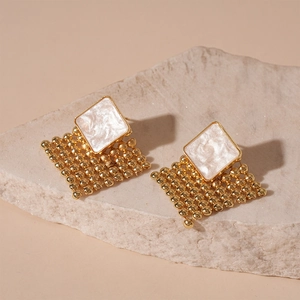 Detail of gold geometric earrings with woven metal beads and pearlescent inlays
