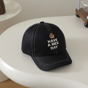 Detail of cartoon bear embroidery and white contrast stitching on black cotton baseball cap