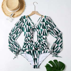 Dettaglio costume intero verde con stampa geometrica, scollo a V e maniche a sbuffo