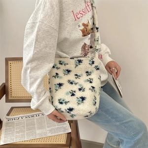 Close-up detail of soft blue floral pattern plush fabric on a fashionable shoulder bag