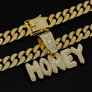 Close-up of iced out golden MONEY pendant with crystal Cuban link chain and clasp
