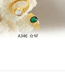 Detailed view of gold textured ring set with green gemstone on white coral stone