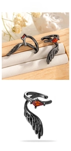 Detailed view of gothic gun-black wing ear cuff with a rhombus ruby gemstone inlay