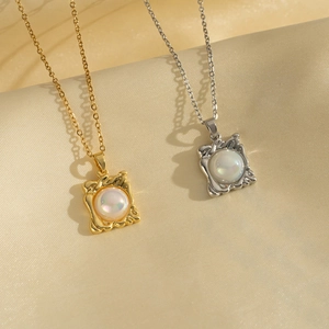 Elegant gold and silver square frame necklaces with pearls on soft silk background