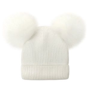 Detail showing soft white knit fabric texture and fluffy plush pom-pom ears on winter hat