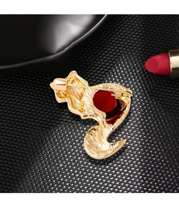 Macro view of vintage gold fox brooch showing the red gemstone and back pin structure