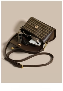 Detail view of houndstooth crossbody bag interior showing phone and cosmetic storage