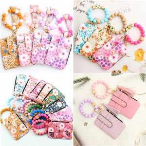 Detail of floral and solid PU leather card holders with silicone bead wristlets and tassels