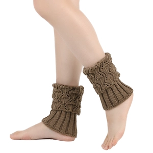 Detailaufnahme dunkelbrauner Strick-Beinstulpen mit Zopfmustern und elastischen Rippbündchen