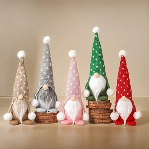 Close-up of knit Christmas gnomes with heart patterns and plush beards on wood