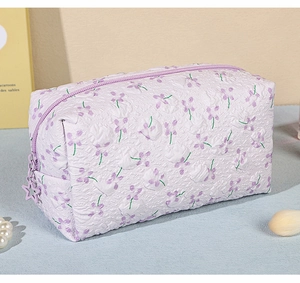Close-up of lilac floral cosmetic bag with bubble texture and star-shaped zipper pull