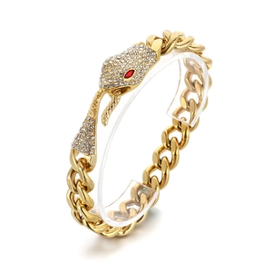 Cuban link bracelet with gold snake head encrusted with white diamonds and red gem eyes