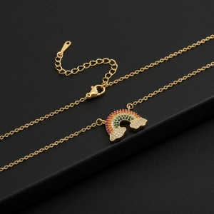 Macro detail of gold rainbow pendant necklace featuring colorful cubic zirconia stones
