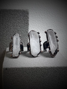 Macro shot of three vintage bronze rings with irregular natural white crystal pillars
