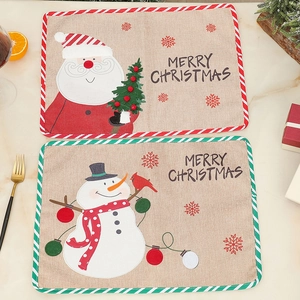 Detail of linen Christmas placemats featuring Santa and Snowman with festive embroidery