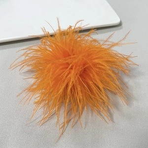 Detail of vibrant orange ostrich feather brooch with soft fluffy texture for party wear