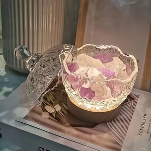 Detail of crystal glass jar with purple stones and warm glowing wooden base