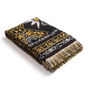 Close-up of bohemian woven blanket with ethnic patterns and decorative fringe details