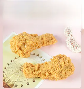 Dettaglio macro di un modello realistico di coscia di pollo fritto su rosa