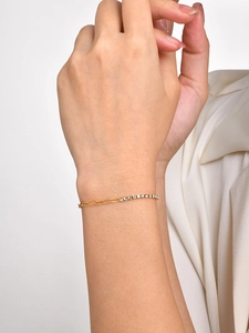 Close-up of a two-tone paperclip chain bracelet with shimmering cubic zirconia on a wrist