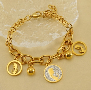 Detailed shot of double-layer golden bracelet with female silhouette and crystal pendants