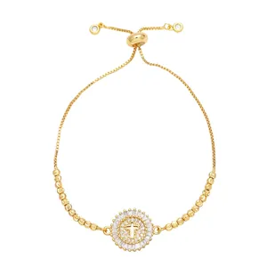 Bracelet ajustable doré à l'or avec pendentif croix orné de zircons cubiques brillants