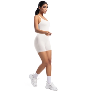 Side view of white one-piece yoga jumpsuit showing elastic fit and minimalist athletic style