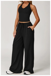 Detail view of black V-neck sports vest and wide-leg trousers set in premium fabric