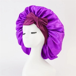 Purple satin bonnet for long hair featuring a large dark red decorative bow on a model
