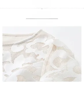 Close-up of intricate white lace hollow-out embroidery on the shoulder of the dress