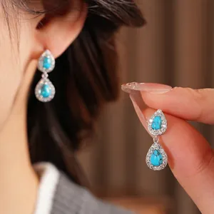 Vintage teardrop silver earrings featuring turquoise stones and cubic zirconia accents