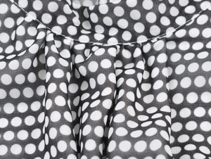 Detail macro shot of black polka dot chiffon fabric with fine single-needle stitching