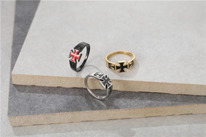 Close-up of retro titanium steel cross rings on stone background for men fashion