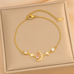 Elegant gold celestial bracelet featuring star and moon charms with zircon inlays