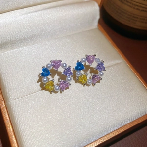 Detail of wreath earrings with colorful heart-shaped stones and white pearls