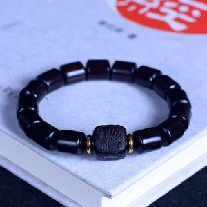 Vue détaillée des perles de santal noir avec une perle centrale carrée gravée