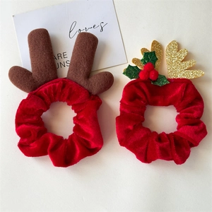 Détail de chouchous de Noël en velours rouge avec bois en feutre et feuilles de paillettes