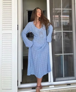 Détail du tricot sur robe longue bleu clair en crochet avec col en V et manches longues