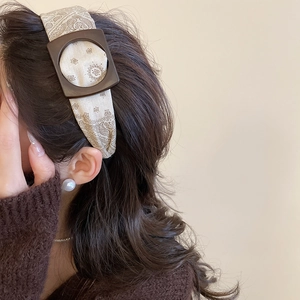 Detail of vintage paisley fabric headband with square resin buckle on model