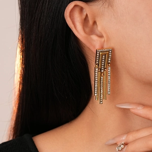 Close-up of vintage geometric tassel earrings with rhinestones on female model